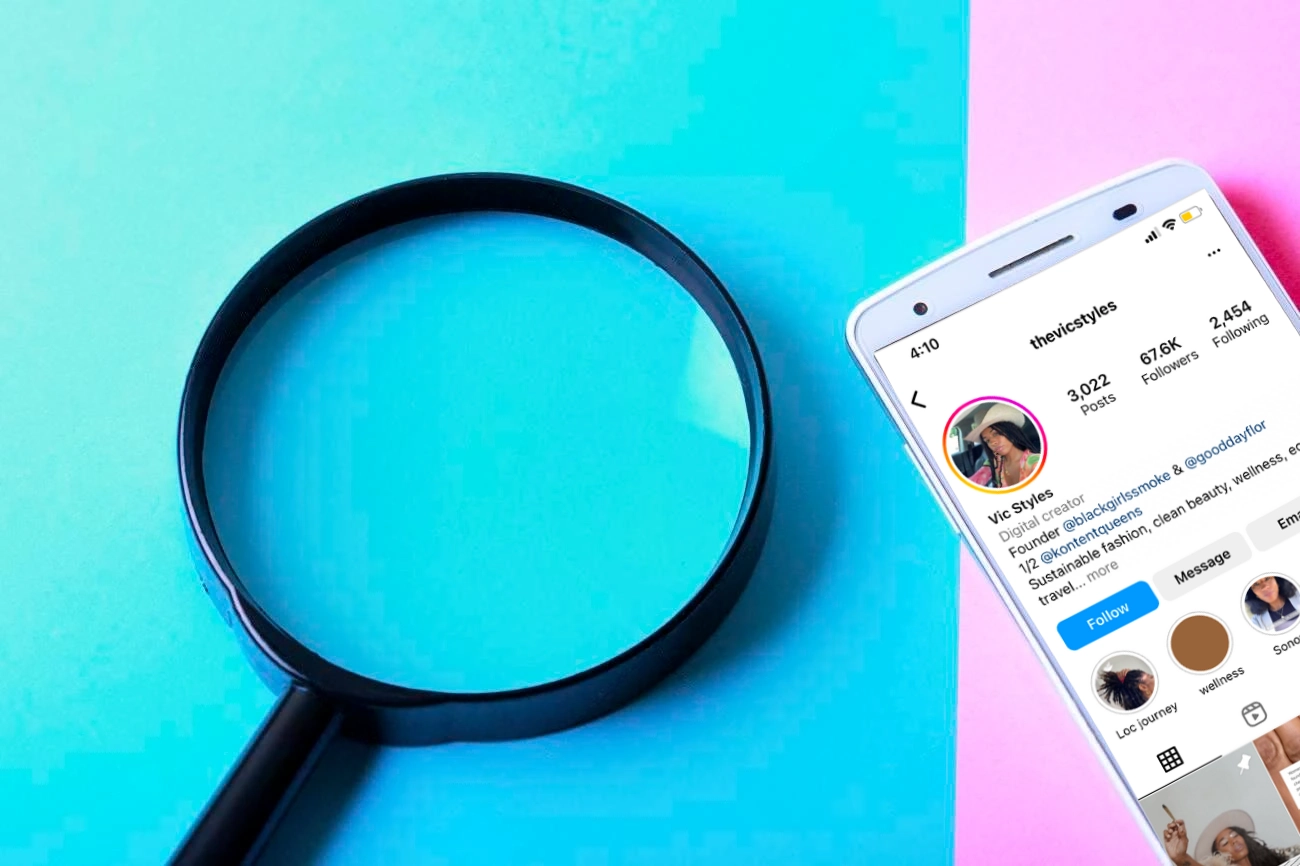 A magnifying glass on a blue and pink background sits next to a smartphone displaying an Instagram profile, perfect for finding creative IG Captions.