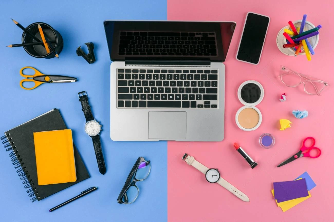 A laptop sits at the center of a split blue and pink background, surrounded by office supplies on one side and makeup items with IG captions inspiration on the other.