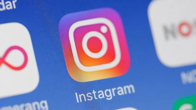 Close-up of the Instagram app icon on a smartphone screen, showcasing the vibrant Instagram camera logo and the word "Instagram" beneath it.